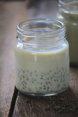 black sesame soy milk in glass on wood