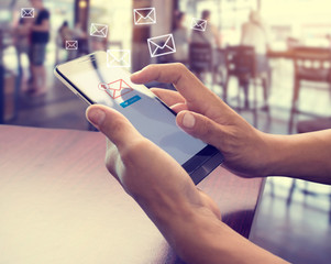Hand of male using mobile phone to sending E-mail message with email symbol and envelope icon. Email marketing concept - obrazy, fototapety, plakaty