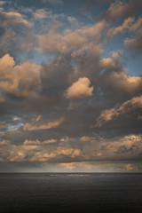 Moody sunset clouds hanging over Wedding Cake Island off Coogee Beach, New South Wales