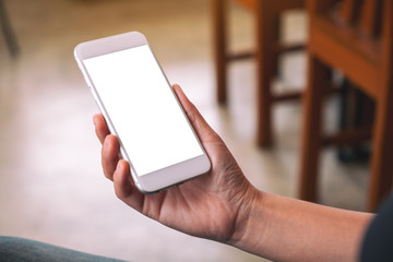 Mockup image of a woman's hand holding white mobile phone with blank desktop screen