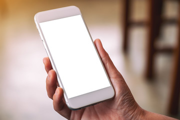 Mockup image of a woman's hand holding white mobile phone with blank desktop screen