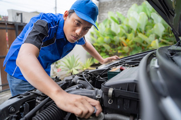 home service mechanic doing some inspection on car's engine