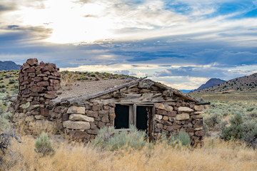 USA, Nevada, Nye County, Grant Range. Sunset over a stone cabin along the Pony Express Route and Overland Stage Line. Red Mountain is visible in the background right.