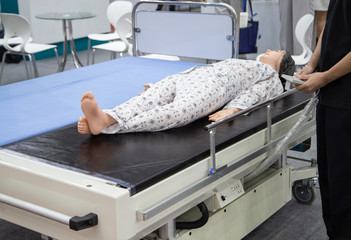 Patient dummy lying on mobile hospital transfer bed