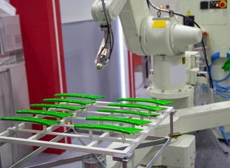 Industrial robot painting motorcycle parts in automotive industry