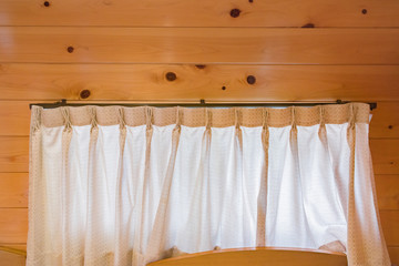 Part of beautiful white curtain on the window in the wooden room. Luxury curtain, home decor.