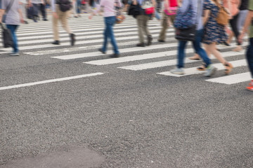 Crowd of people in motion blurred crossing the street in japan.