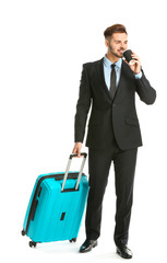 Handsome young businessman with luggage on white background