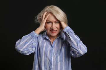 Stressed mature woman on dark background