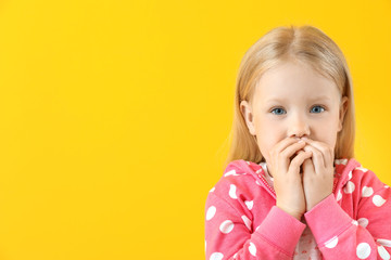 Portrait of adorable little girl on color background