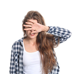 Young woman covering her eyes on white background