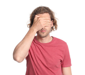 Young man covering his eyes on white background