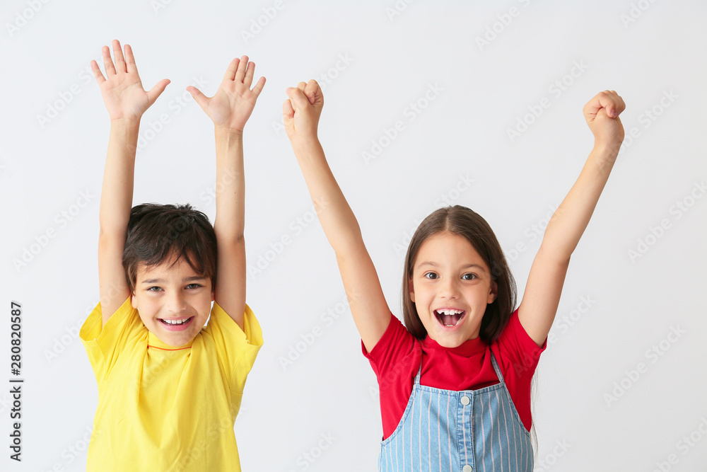 Wall mural Portrait of happy children on light background