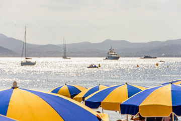Sea bay with yachts boats and beach umbrella in Cannes