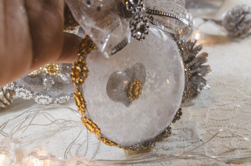 Transparent Christmas balls snowed inside and with a heart inside decorated with a gold and silver bow