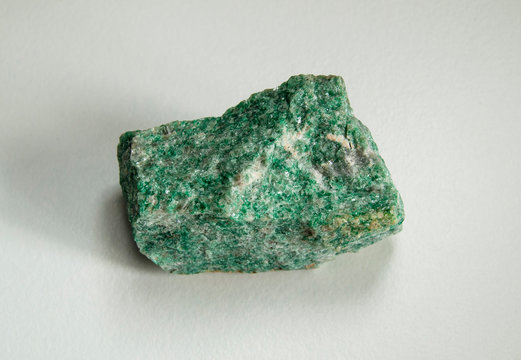 Macro shooting of natural mineral rock specimen - raw listvenite (Listwanite) stone. Origin: Russian Federation, Ural. On a white background.