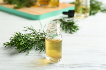 Composition with bottle of conifer essential oil on white wooden table