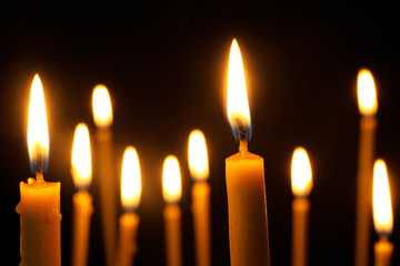Burning candles on dark background. Symbol of sorrow