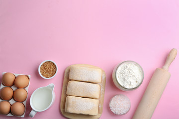 Puff pastry dough and ingredients on pink background, flat lay. Space for text