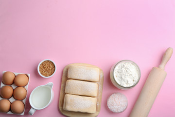 Puff pastry dough and ingredients on pink background, flat lay. Space for text