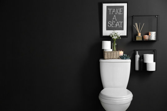 Decor Elements, Necessities And Toilet Bowl Near Black Wall, Space For Text. Bathroom Interior