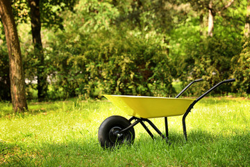 Wheelbarrow on grass outside, space for text. Gardening tool