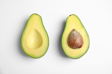 Cut fresh ripe avocado on white background, top view