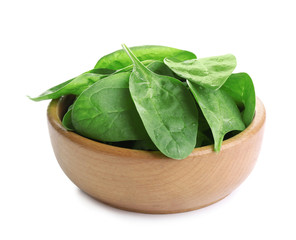 Fresh green healthy baby spinach leaves in wooden bowl isolated on white