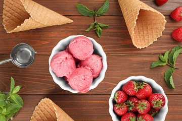 Flat lay composition with delicious strawberry ice cream on wooden table