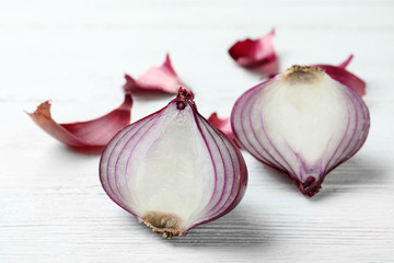 Halves of red onion on white wooden table