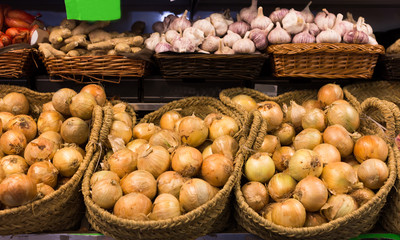 bulb onion in wicker baskets on market counter