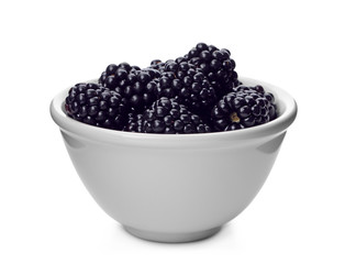 Ceramic bowl of tasty ripe blackberries on white background