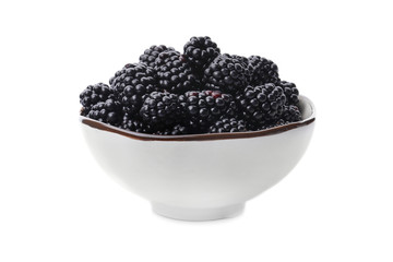 Ceramic bowl of tasty ripe blackberries on white background