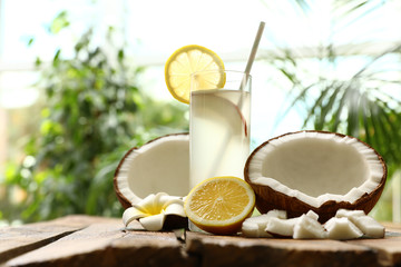 Composition with glass of coconut water and lemon on wooden table