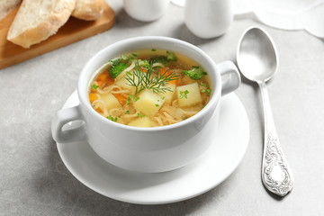 Dish of fresh homemade vegetable soup served on light grey table