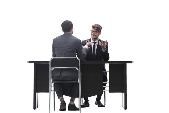 Two Businessmen Talking, Sitting At His Desk