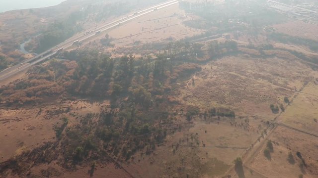 Aerial Shot From Plane Crossing Over Highway Next to Large Lake