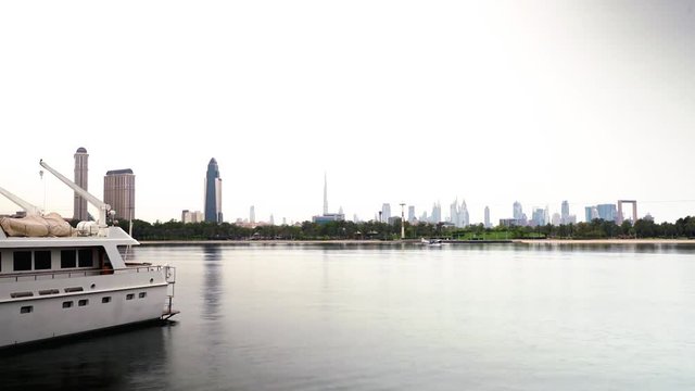 Timelapse of Dubai Waterfront and Skyline With Speedboats on Creek