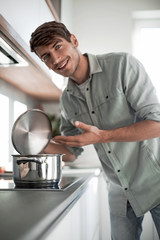 close up. a young man standing near the kitchen stove