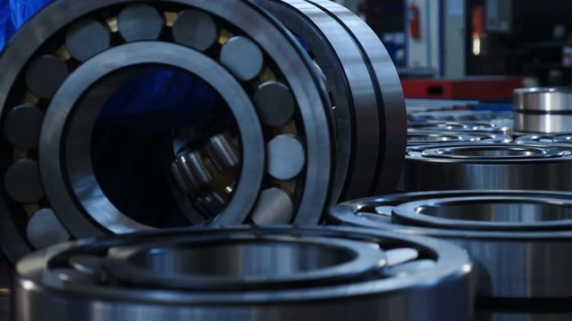 Industry and Machinery concept. Manufacture of bearings at the factory. Set of various gears and ball bearings. spare parts at warehouse. Close up. 4k