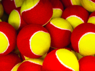 many yellow and red tennis balls in the sports shop