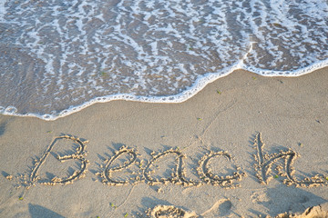 beautiful sandy beach and soft blue ocean wave and text Beach