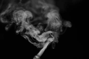 White smoke on a black background. Texture of smoke. Clubs of white smoke on a dark background for an overlay