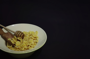 Corn flakes in a plate. Breakfast from flakes with honey and milk. Fast breakfast with corn flakes.
