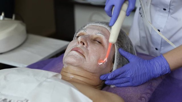 girl at the beautician. Cleaning the face. Darsonvalization.
