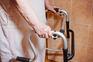 Hands of an elderly woman rests on on a walker. medical and healthcare concept.