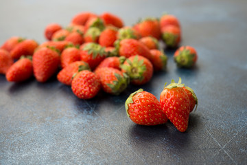 Fresh red strawberries on a blue concrete background.
