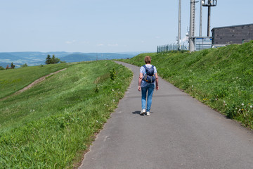 Obraz premium Elderly female hiker at Wasserkuppe Mountain in Hesse in Germany.