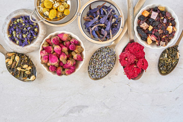 Different herbal and fruit dry teas on marble table. Top view flat lay with copy space