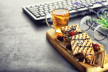 Sweet dessert with waffles and berries for tea at work.